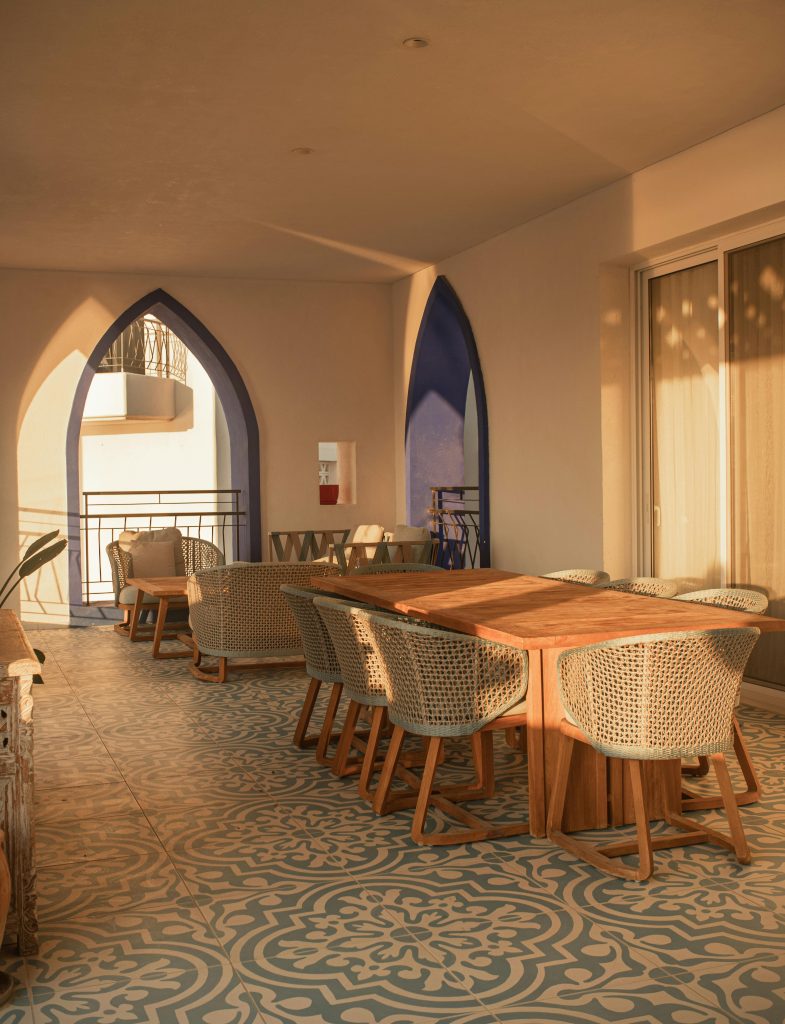 Open-plan Cyprus apartment with sea-view balcony, light wood floors, and a small dining table in mid-morning daylight.